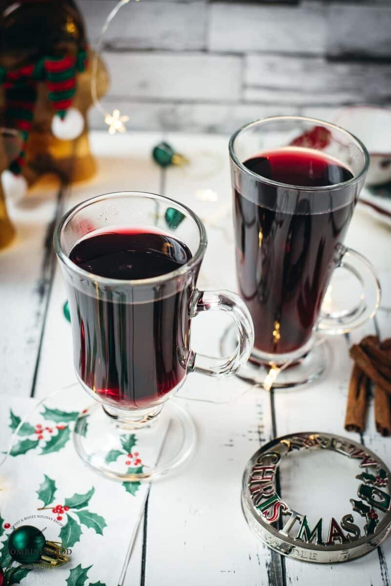 Gorgeous glasses filled with mulled placed next to Christmas decor.