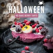 Hauntingly delicious mini Oreo tarts filled with a berry mix ganache, garnished with a creepy gummy eye, frozen berries and whipped cream. Placed on a black plate covered with spider webs.