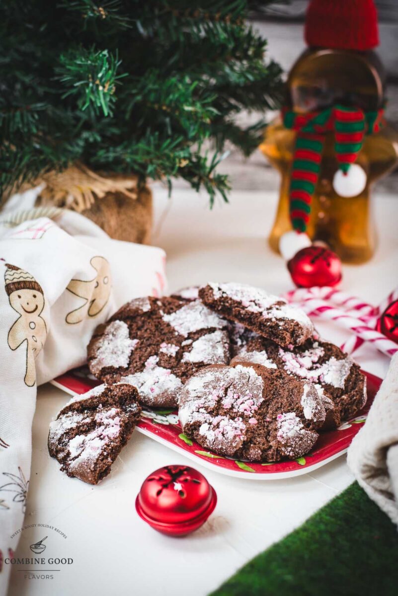 Gorgeous chocolate peppermint crinkle cookies placed on christmassy plate.