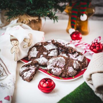 Gorgeous chocolate peppermint crinkle cookies placed on christmassy plate.