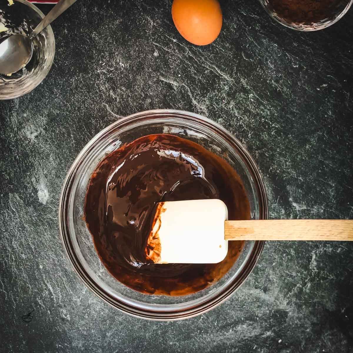 Bowl with melted chocolate and spatula.