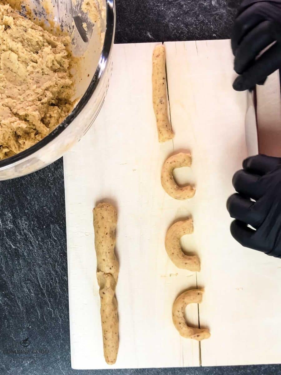 Roll the dough into sticks and cut it into small pieces before shaping them into crescents.