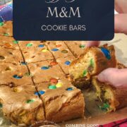 Hand taking a M&M cookie bar after slicing.