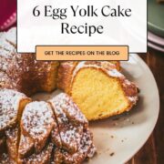 Gorgeous six egg yolk bundt cake, dusted with powdered sugar, and placed on white plate.