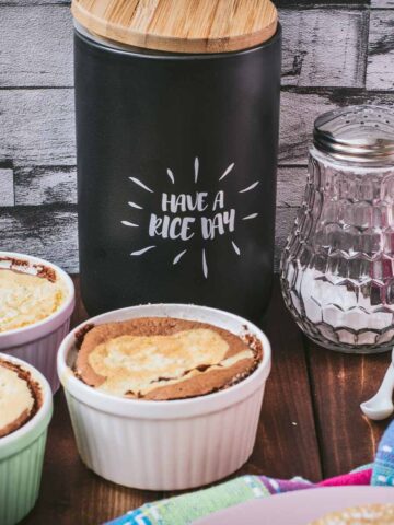 Delicious marbled rice pudding mini casseroles placed on wooden board.