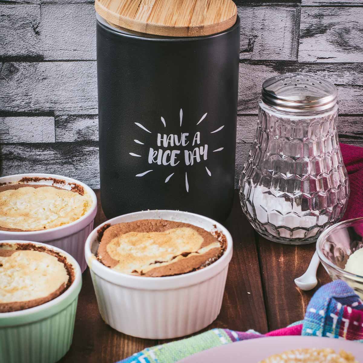 Delicious marbled rice pudding mini casseroles placed on wooden board.