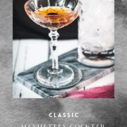 Sophisticated Manhattan cocktail, garnished with a Maraschino cherry, placed on a marbled plate.