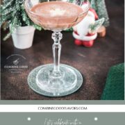 Festive chocolate martini with a white chocolate snowflake garnish, placed on mirrored coaster next to a Santa clause figurine.