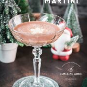 Festive chocolate martini with a white chocolate snowflake garnish, placed on mirrored coaster next to a Santa clause figurine.