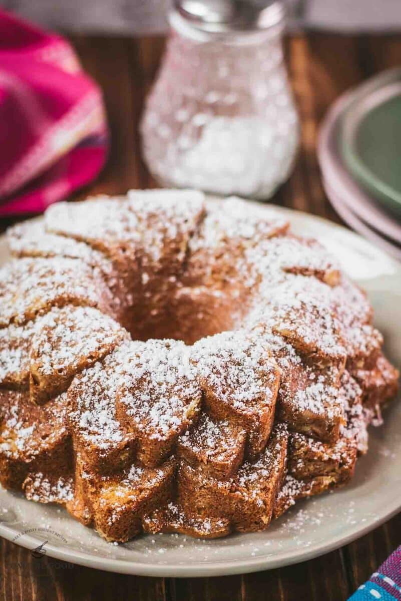 Gorgeous six egg yolk bundt cake, dusted with powdered sugar, and placed on white plate.