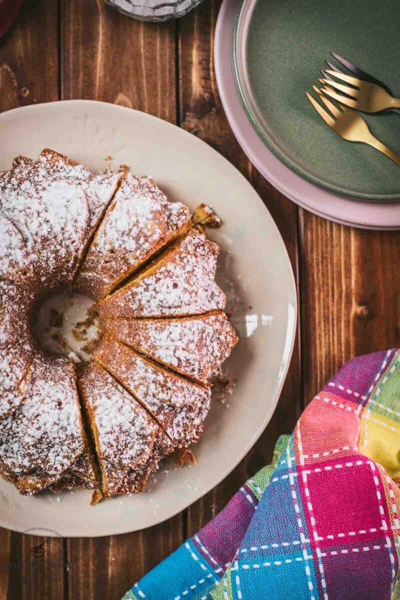 Gorgeous six egg yolk bundt cake, dusted with powdered sugar, and placed on white plate.