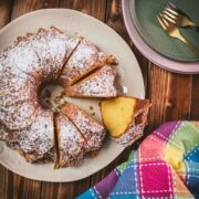 Gorgeous six egg yolk bundt cake, dusted with powdered sugar, and placed on white plate.