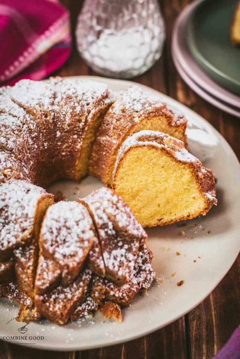 Gorgeous six egg yolk bundt cake, dusted with powdered sugar, and placed on white plate.