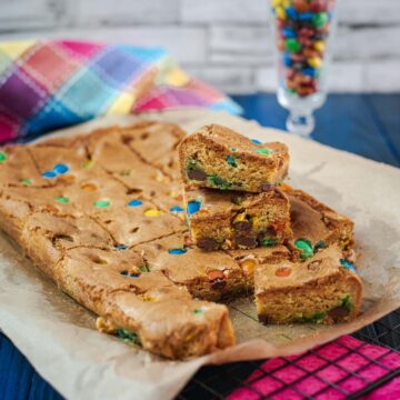 Delicious M&M cookie bars on parchment paper.