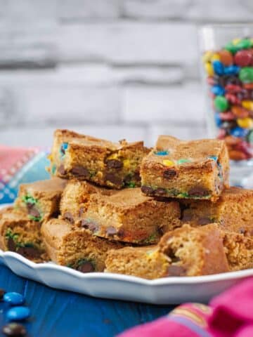 Delicious M&M cookie bars on white plate.