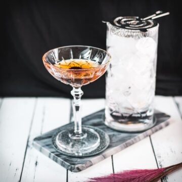 Sophisticated Manhattan cocktail, garnished with a Maraschino cherry, placed on a marbled plate.