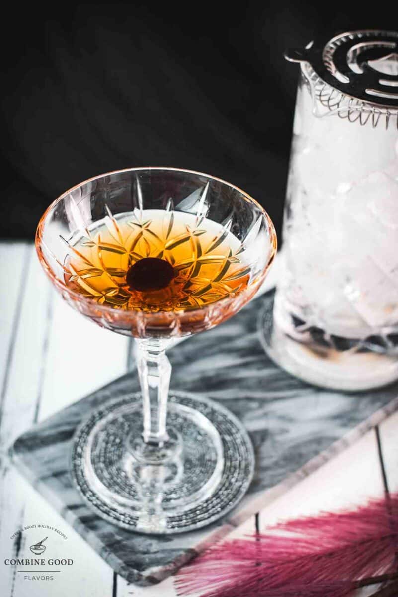 Sophisticated Manhattan cocktail, garnished with a Maraschino cherry, placed on a marbled plate.