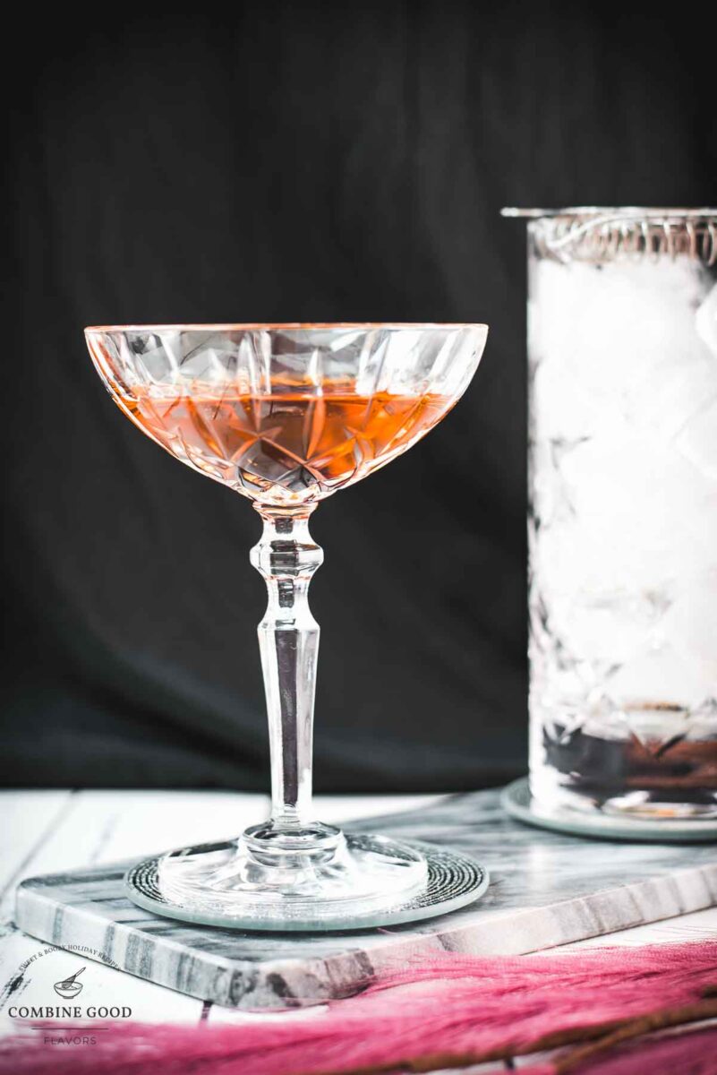 Sophisticated Manhattan cocktail, garnished with a Maraschino cherry, placed on a marbled plate.