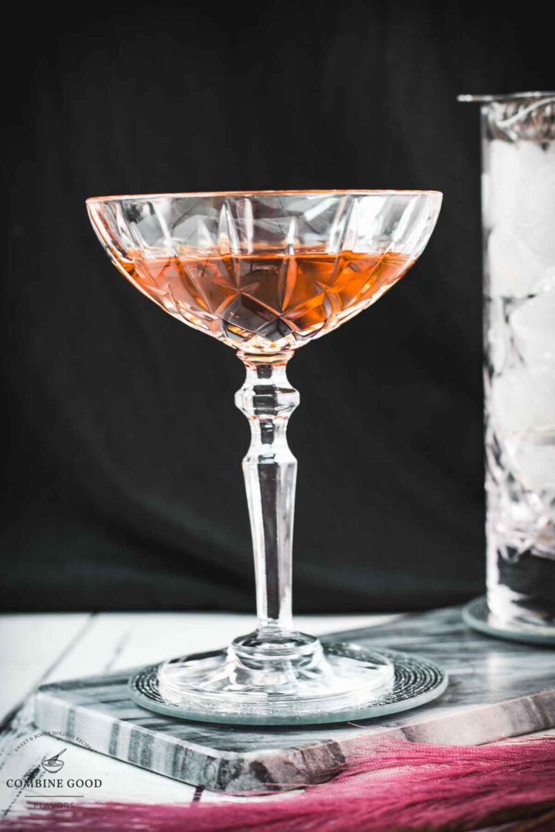 Sophisticated Manhattan cocktail, garnished with a Maraschino cherry, placed on a marbled plate.