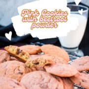 Gorgeous pink cookies on white plate, next to a glass on milk.