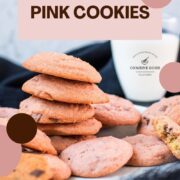 Gorgeous pink cookies on white plate, next to a glass on milk.