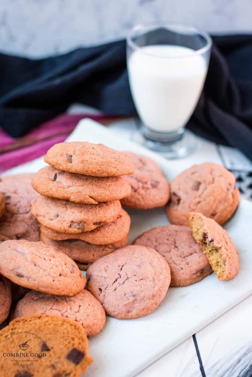 Gorgeous pink cookies on white plate, next to a glass on milk.