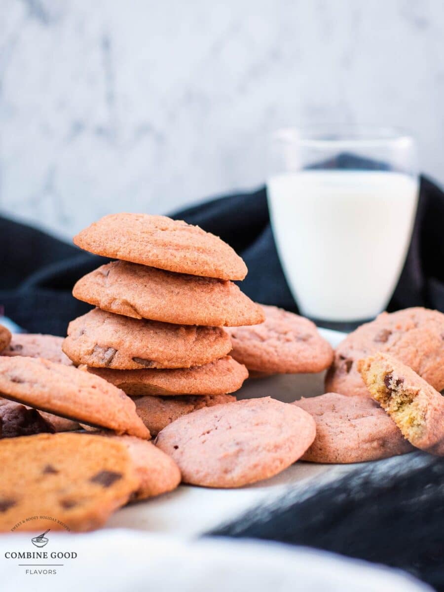 Gorgeous pink cookies on white plate, next to a glass on milk.