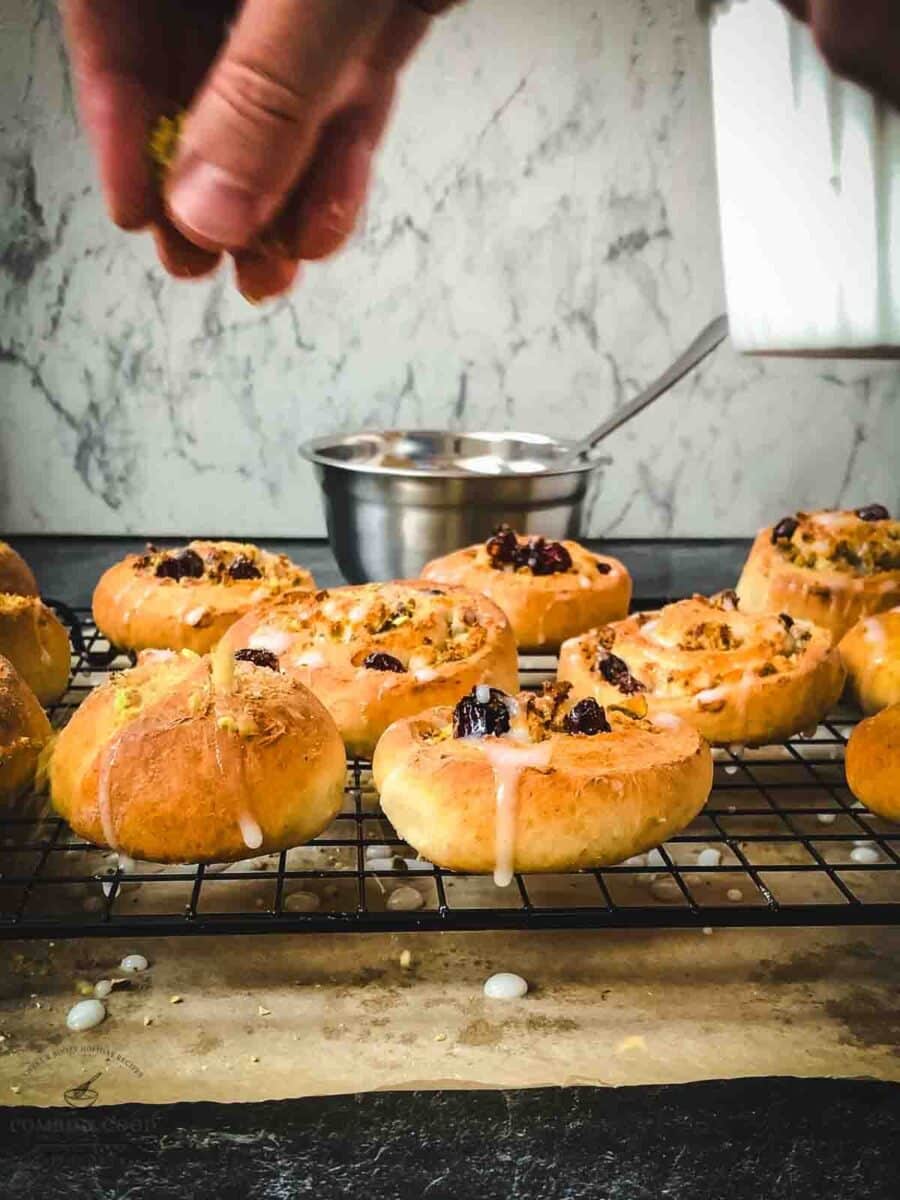 Sprinkle the glazed pistachio sweet rolls with ground pistachios.