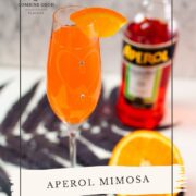 Gorgeous sparkling wine glass, with engraved heart and two crystals, filled with delicious Aperol Mimosa. Placed on heartshaped black slate coaster.