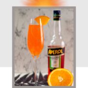 Gorgeous sparkling wine glass, with engraved heart and two crystals, filled with delicious Aperol Mimosa. Placed on heartshaped black slate coaster.