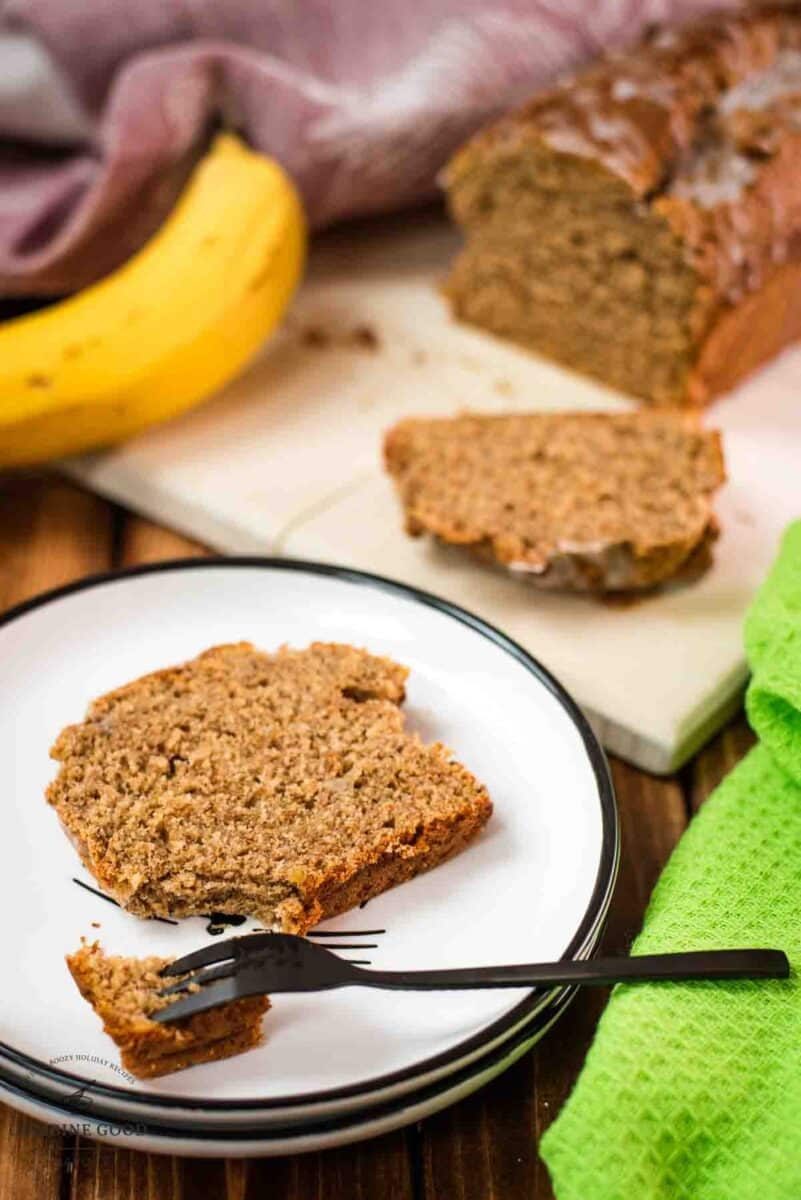 Banana bread slice placed on white plate.