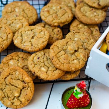 Soft, chewy and sweet strawberry cookies with white chocolate chips scattered on a cooling rack.