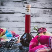 Delicious homemade Chambord, blackberry raspberry liqueur, on gorgeous flask, placed on black slate.