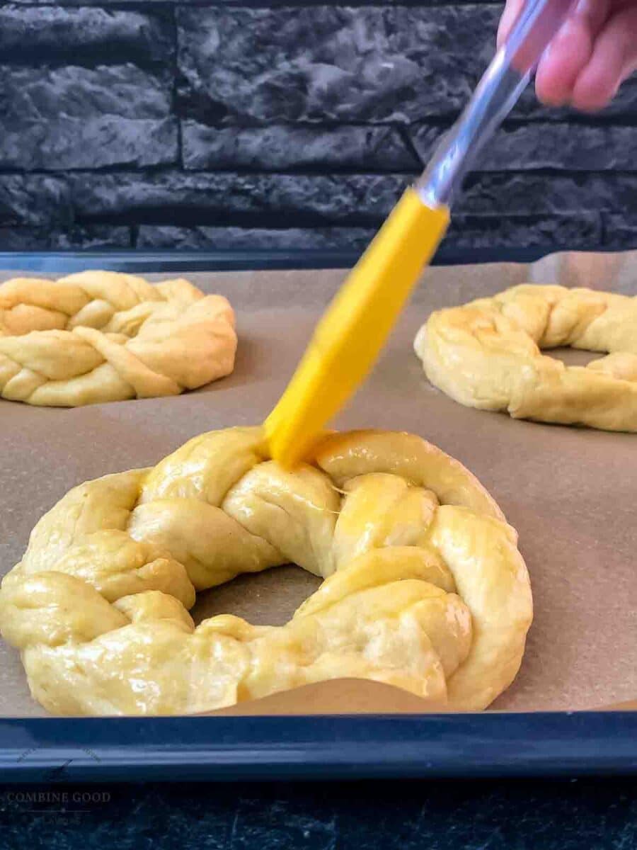 Brush the Easter bread wreaths with egg wash before baking.