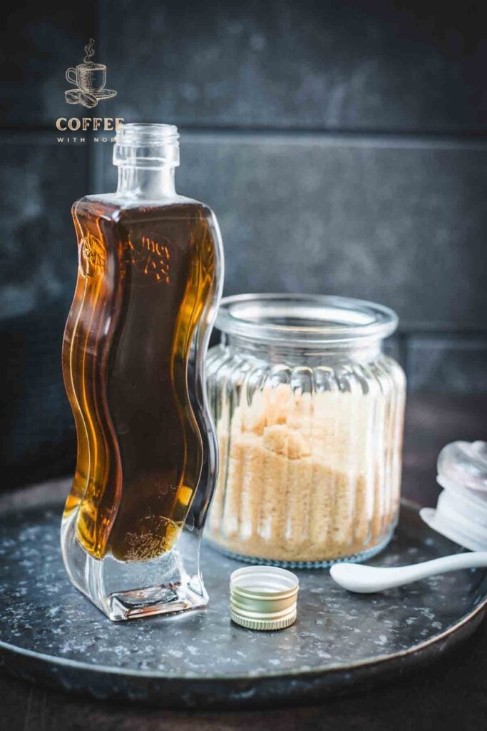 Gorgeous, curved bottle, filled with delicious brown sugar simple syrup. Placed on dark plate.