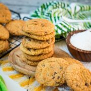 Delicious coconut chocolate chip cookies, stacked on a wooden plate.