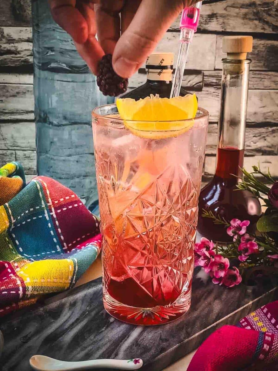 Garnish with a lemon wedge and a blackberry.
