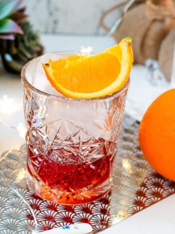 Gorgeous Negroni cocktail, served with a juice orange wedge.