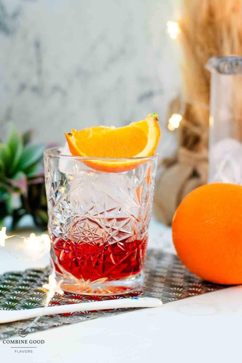 Gorgeous Negroni cocktail, served with a juice orange wedge.