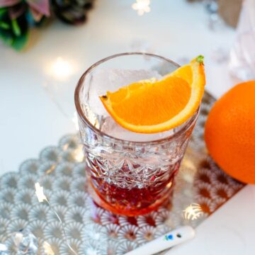 Gorgeous Negroni cocktail, served with a juice orange wedge.