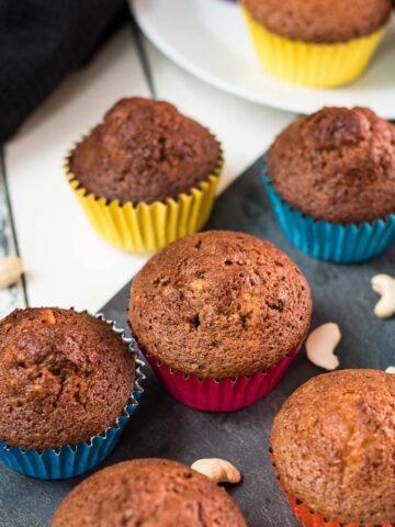 Delicious rum cashew muffins, placed on dark slate plate.