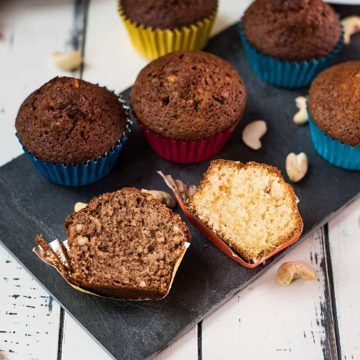 Two rum muffin halves, one with Dutch cocoa, the other without. Placed on a dark slate plate.