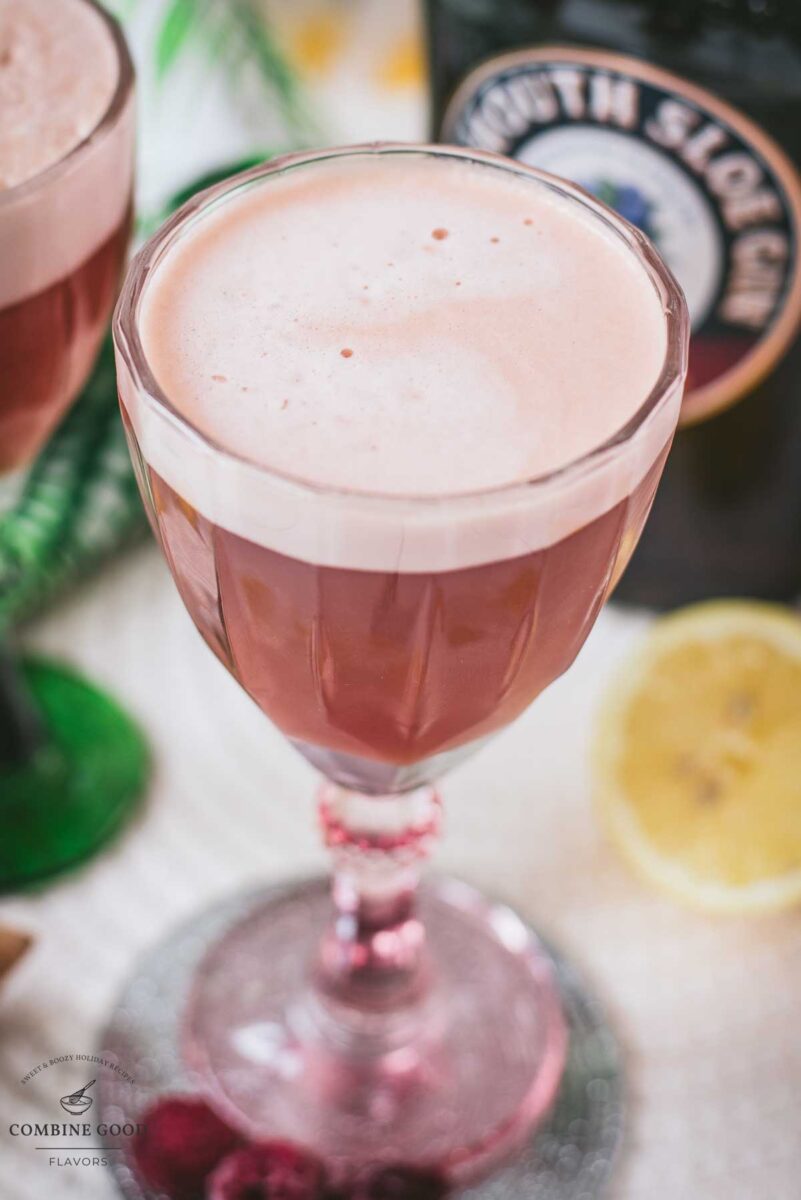 Divine ruby fizz cocktail, placed on mirrored coaster and served in a red and a green glass.