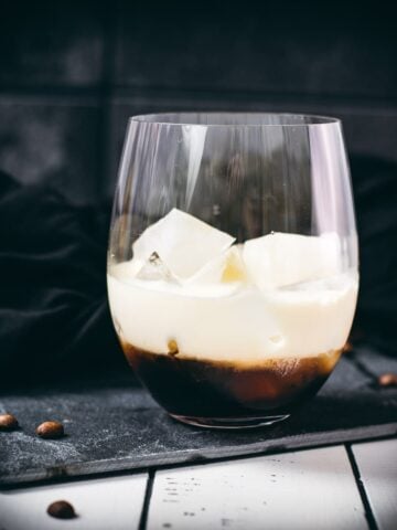 Simple GT glass, filled with delicious brown sugar white Russian. Placed on a black slate plate.