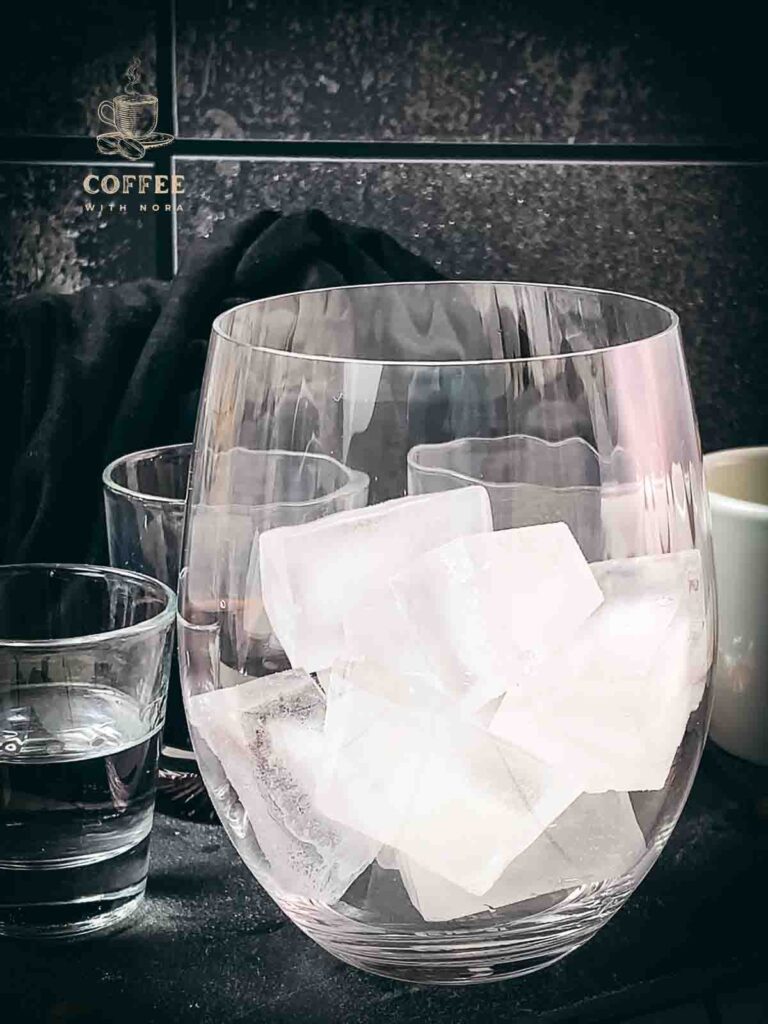 Fill a glass with cubed ice.