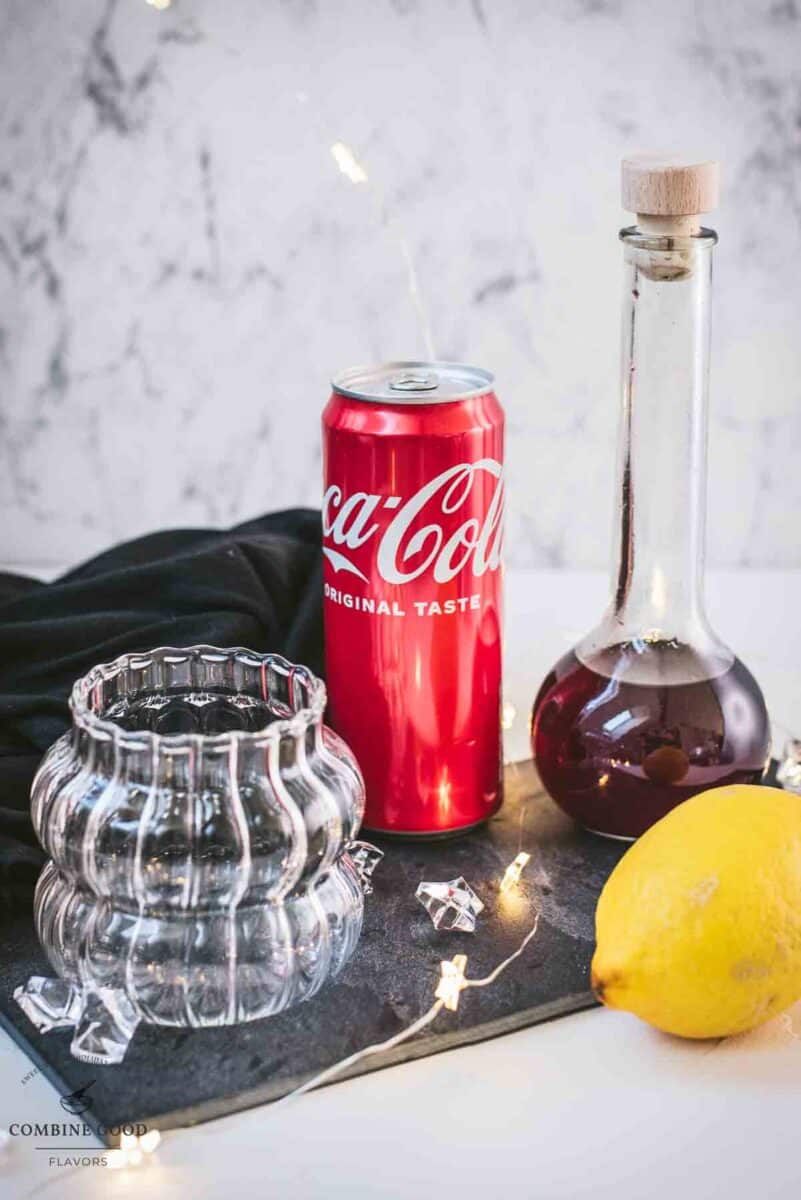 Chambord coke cocktail ingredients - coke, lemon juice, cubed ice, and homemade blackberry raspberry liqueur.
