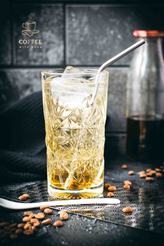 Highball glass filled with a delicious, golden-colored coffee soda.