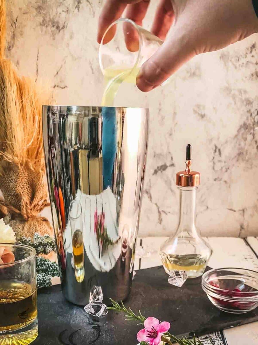 Add freshly squeezed lemon juice to the cocktail shaker.