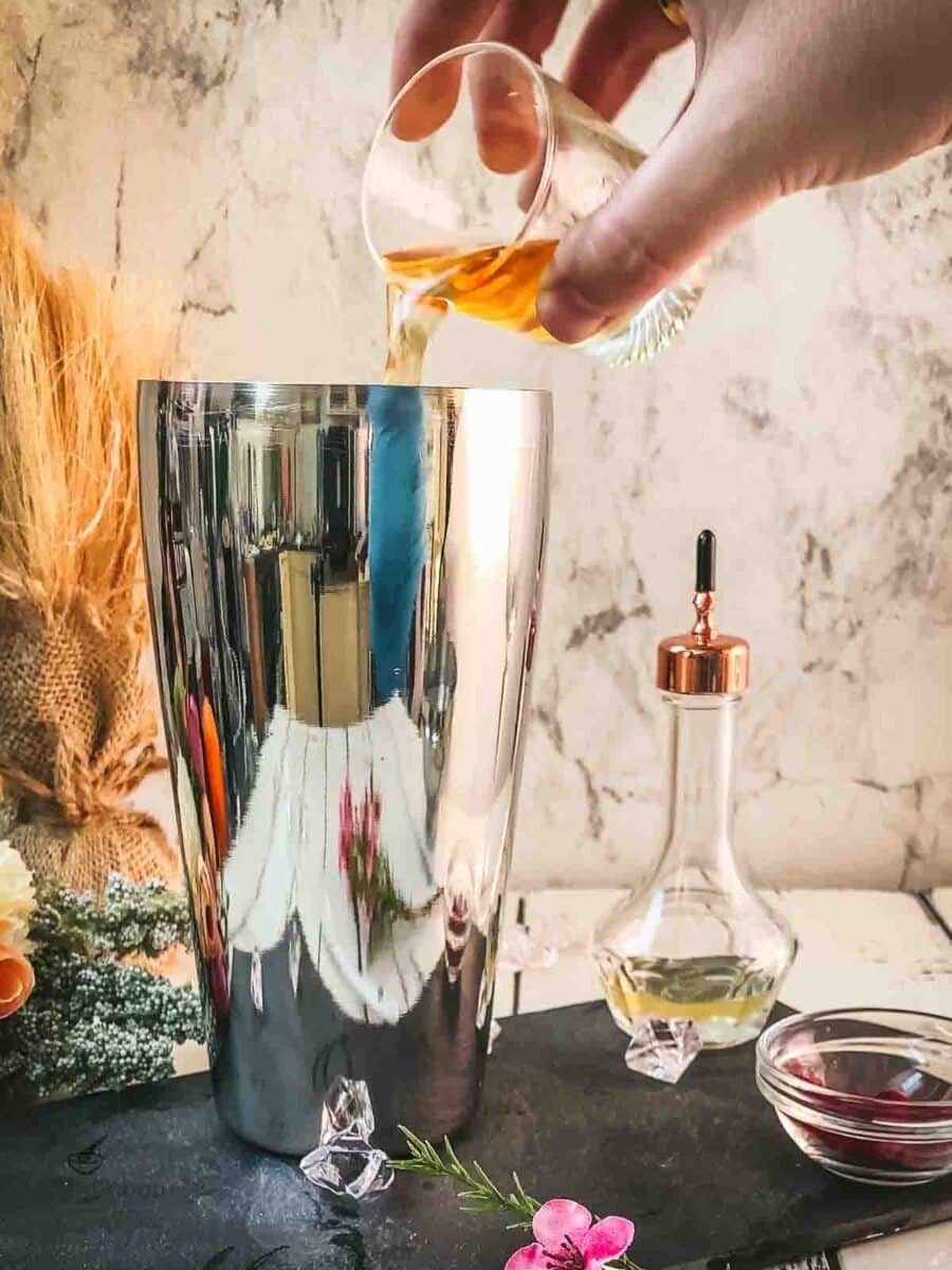 Add Bourbon to the cocktail shaker.