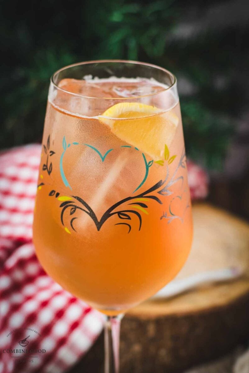 Delicious Zirben Spritzer served in white wine glass. Placed on wooden ground.pps.